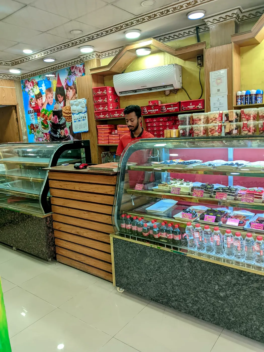 Arabian Cake & Sweets staff serving from pastry display